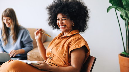 Happy smiling woman with notepad and pen.jpg